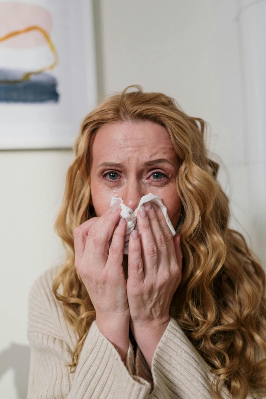 a woman blowing her nose with a tissue, evanna lynch, at home, shot with sony alpha 1 camera, people crying