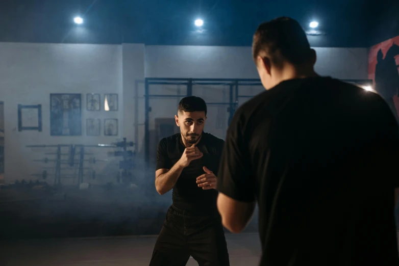 a man in black shirt standing next to another man in black shirt, inspired by Ma Quan, pexels contest winner, boxing stance, ( ( theatrical ) ), manuka, alessio albi