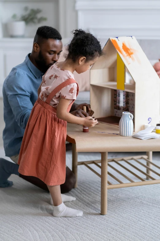 a man and a little girl playing with a doll house, pexels contest winner, conceptual art, sitting on a mocha-colored table, ikea, sustainable materials, promotional image