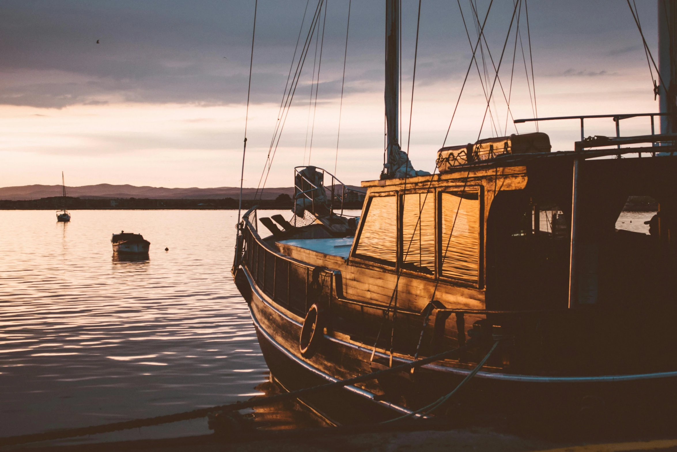 a boat that is sitting in the water, pexels contest winner, peaceful evening harbor, orkney islands, vintage vibe, he's on an old sailing boat