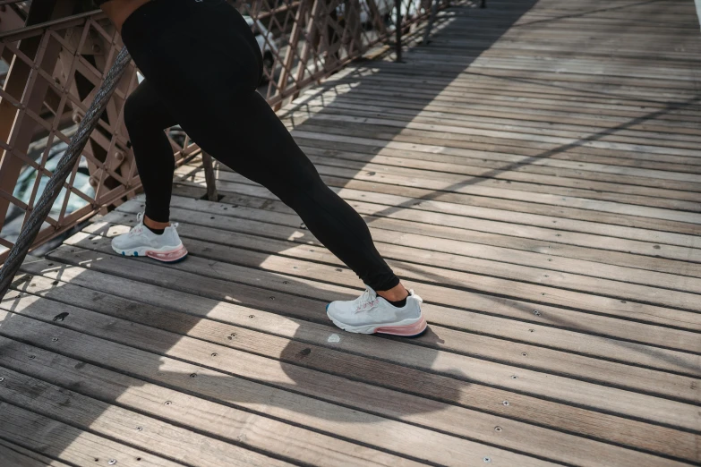 a woman standing on top of a wooden bridge, by Emma Andijewska, pexels contest winner, happening, running shoes, thighs thighs thighs thighs, side view of her taking steps, lunging at camera :4