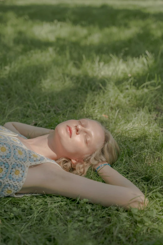 a woman laying on top of a lush green field, unsplash, magic realism, portrait of elle fanning, looking tired, low quality photo, color footage