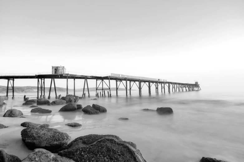 a black and white photo of a pier, pexels contest winner, at the seaside, hd footage, long exposure photo, 2 5 6 x 2 5 6 pixels