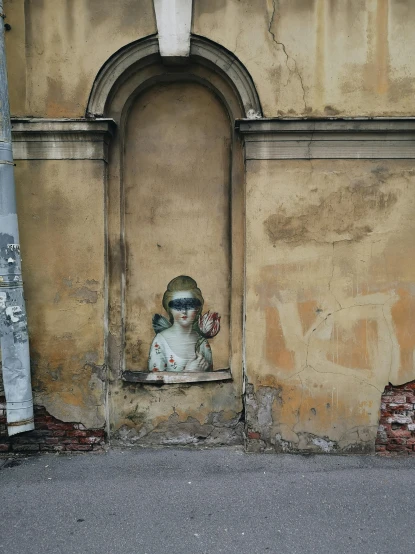 a statue that is on the side of a building, a painting, pexels contest winner, street art, halo over her head, spying, in style of old painting, eyeballs in the walls