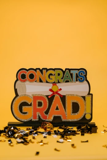 a congrats sign sitting on top of a pile of confetti, a cartoon, academic art, yellow backdrop, mid-shot, post graduate, wooden