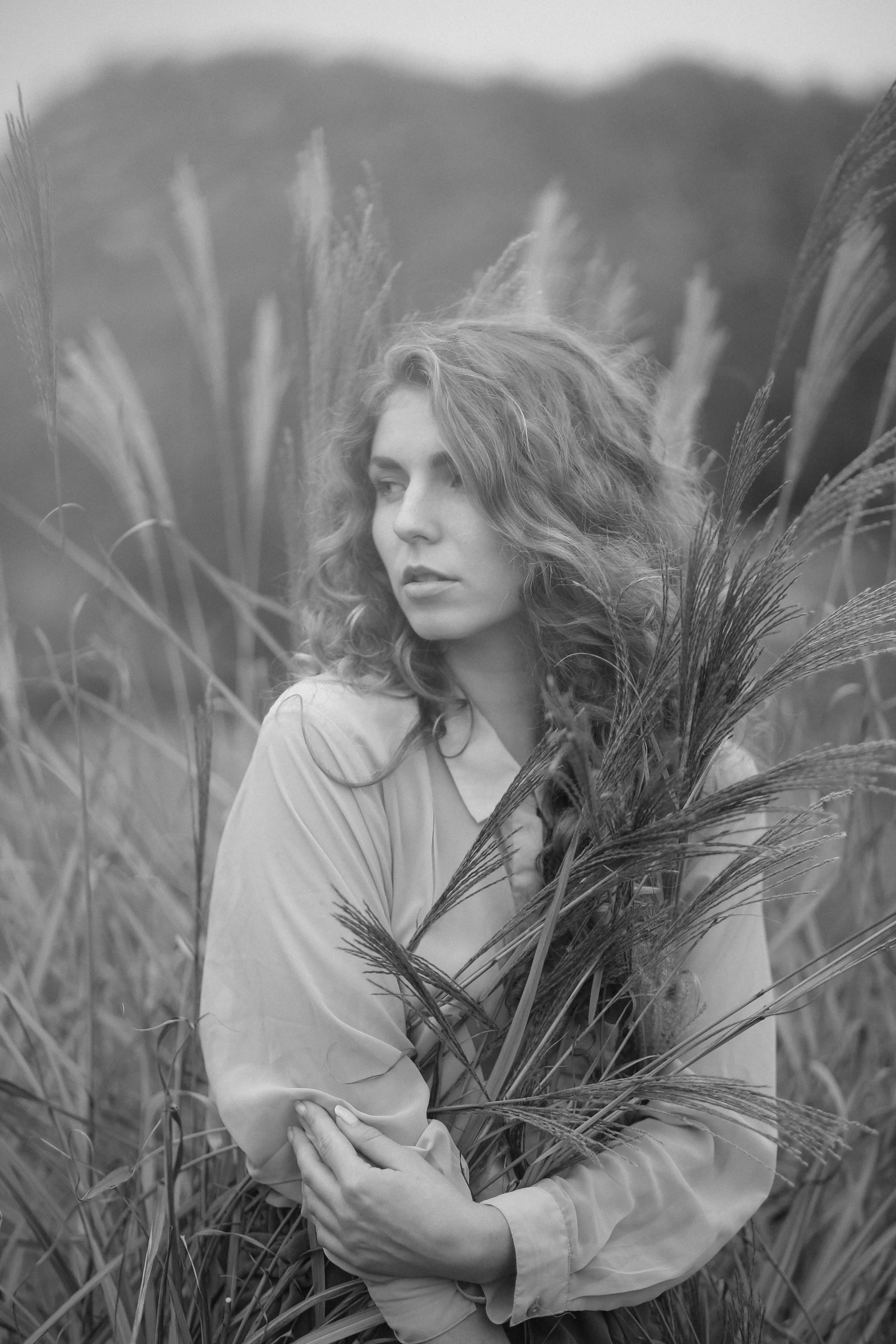 a black and white photo of a woman in a field, by Felix-Kelly, art photography, portrait image, medium format, feathered hair, 15081959 21121991 01012000 4k