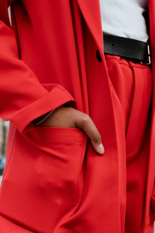 a close up of a person wearing a red suit, by Nina Hamnett, wearing a duster coat, pockets, monochrome, colourful clothing