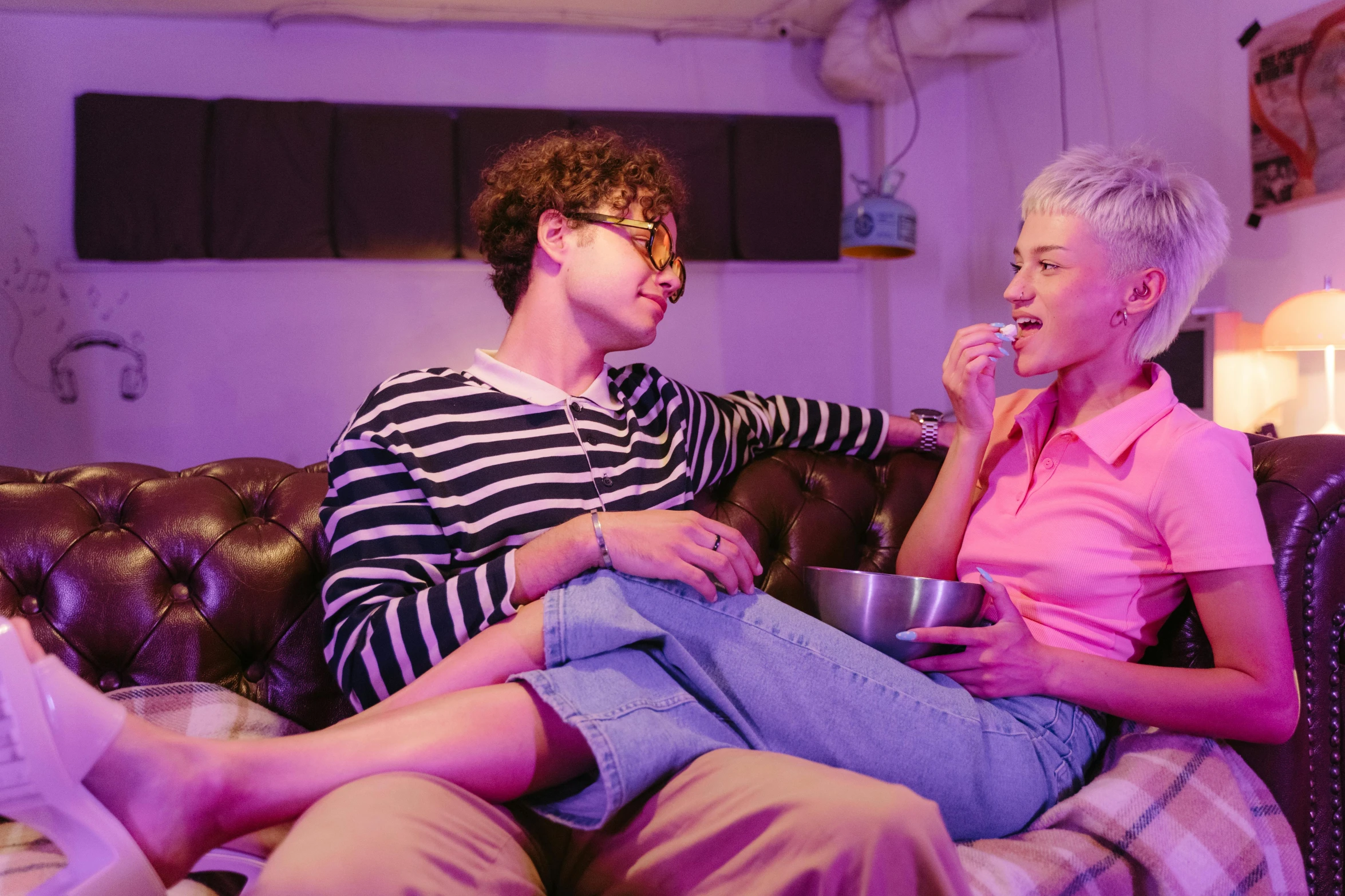 a man and a woman sitting on a couch, by Nick Fudge, pexels, serial art, purple scene lighting, eating, cai xukun, lgbtq