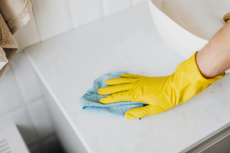 a person in yellow gloves cleaning a sink, by Liza Donnelly, pexels, fan favorite, on a white table, collection product, [ cinematic