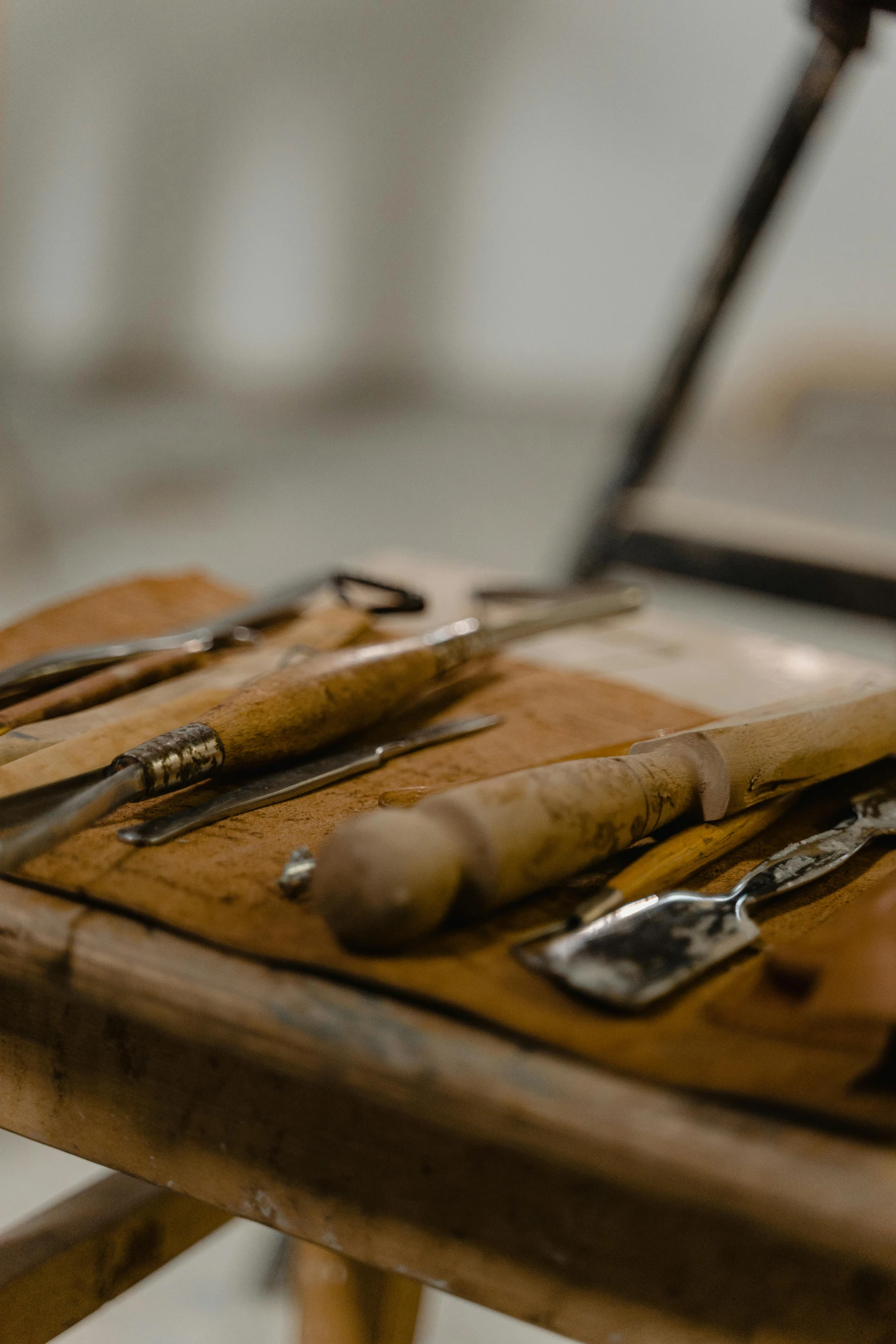 a set of tools sitting on top of a wooden table, inspired by Cornelis Claesz van Wieringen, trending on pexels, arts and crafts movement, ivory carving, in a workshop, banner, metal readymade