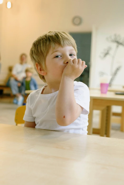 a little boy that is sitting at a table, coughing, in a classroom, thumbnail, polished : :