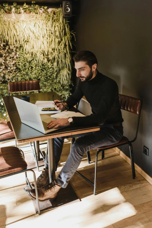 a man sitting at a table with a laptop, by Sebastian Vrancx, pexels contest winner, wide full body, seasonal, gif, sleek