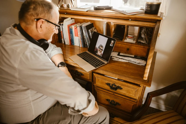 a man sitting in front of a laptop computer, by Emma Andijewska, pexels contest winner, father figure image, long distance shot, calmly conversing 8k, brown
