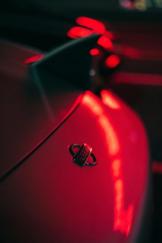 a close up of a car with red lights, sitting on a red button, taken with sony alpha 9, high-quality photo, glossy paint
