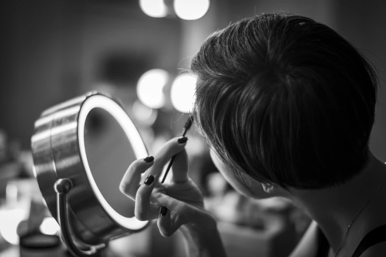 a woman brushing her teeth in front of a mirror, a black and white photo, by Adam Marczyński, pexels contest winner, reflection of led lights, wearing eye shadow, making of, item