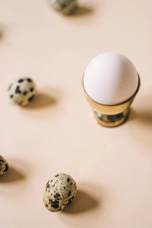 a group of eggs sitting on top of a table, a picture, by Jan Tengnagel, trending on unsplash, metallic brass accessories, white with chocolate brown spots, jisu choe, thumbnail