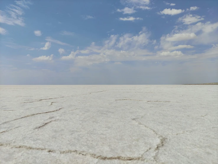 a person on a skateboard in the middle of the desert, an album cover, inspired by Scarlett Hooft Graafland, land art, white salt, panorama view of the sky, background image, hyperdetailed photograph