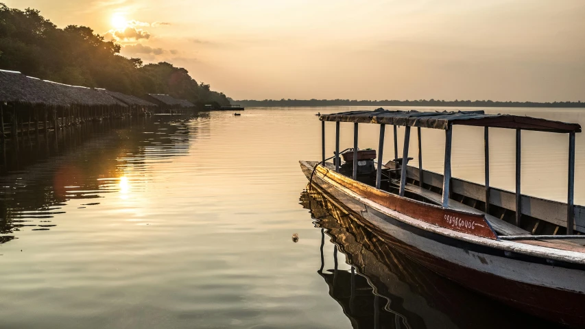 a boat that is sitting in the water, by Peter Churcher, pexels contest winner, sumatraism, sunlight reflected on the river, in an african river, golden morning light, grey