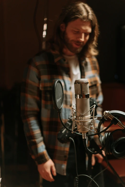 a man standing in front of a microphone, in a studio hollow, liam, item, less detailing