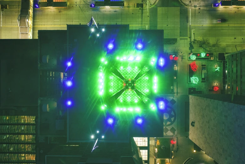 a large clock mounted to the side of a building, a hologram, unsplash contest winner, kinetic art, aerial view top down, glowing green lights, square, kaleidoscopic