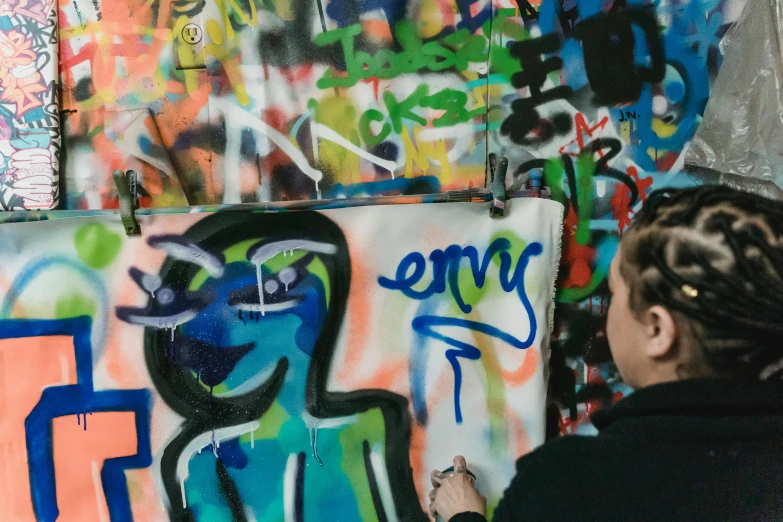 a woman is painting graffiti on a wall, by Emma Andijewska, trending on pexels, graffiti, 144x144 canvas, painting on a badge, arney freytag, arc de triomphe full of graffiti