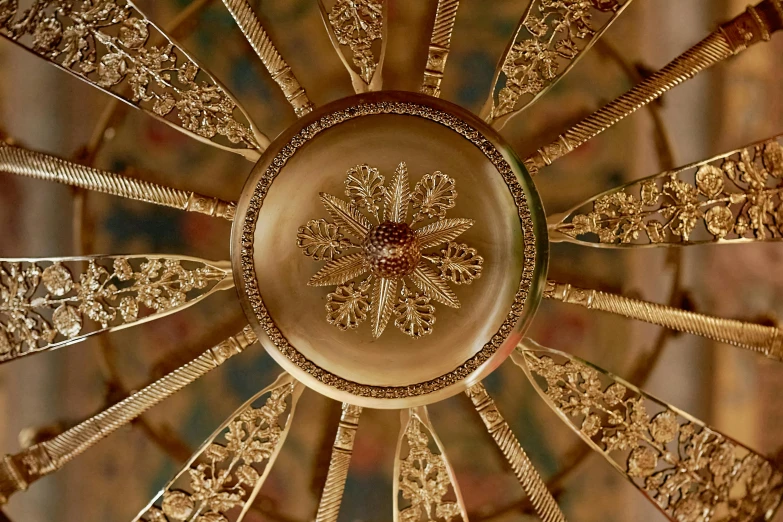 a gold chandelier hanging from a ceiling in a room, inspired by William Hoare, close-up from above, rosette, gold inlay, bronze