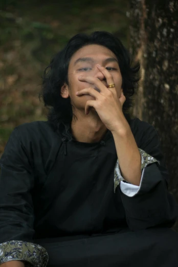 a man sitting under a tree smoking a cigarette, an album cover, unsplash, sumatraism, ((portrait)), androgyny, very very low quality picture, a wooden