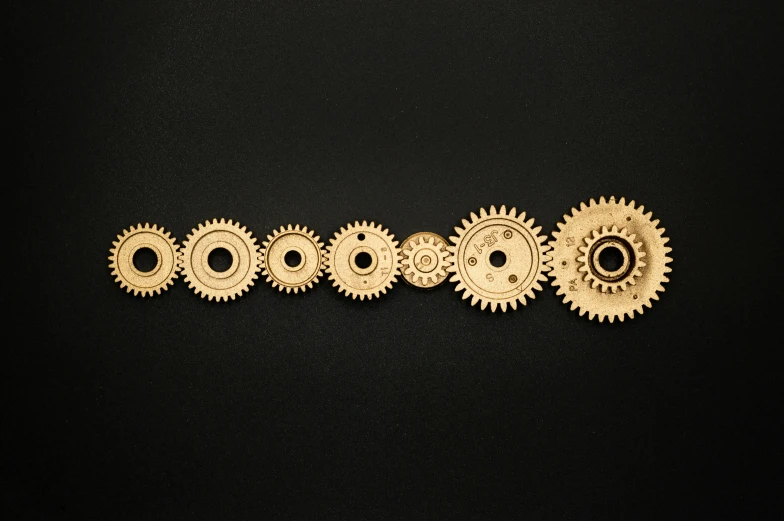 a row of gears on a black surface, an album cover, pexels contest winner, kinetic art, brass plated, ((gears)), computer, knolling