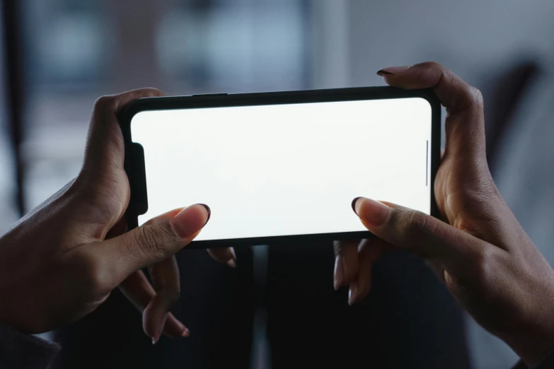 a person holding up a smart phone with a white screen, pexels, video art, strong backlight, avatar image, extra wide, back to camera