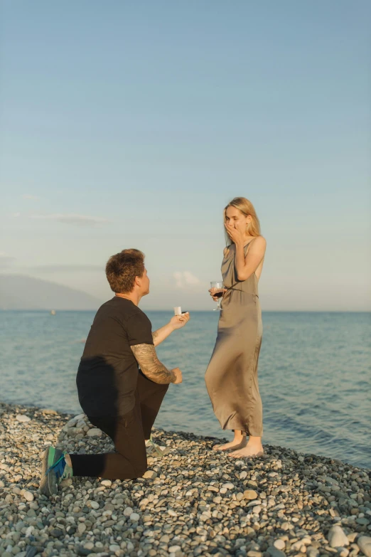 a man proposing a woman on the beach, by Julia Pishtar, happening, on ocean, square, high quality upload, single