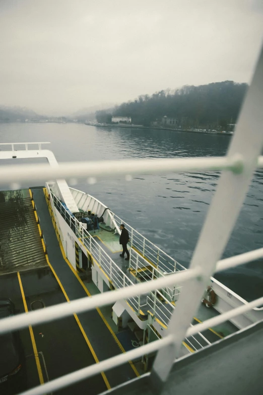 a couple of people standing on top of a boat, on a bridge, snowy fjord, hazy and dreary, cinematic”