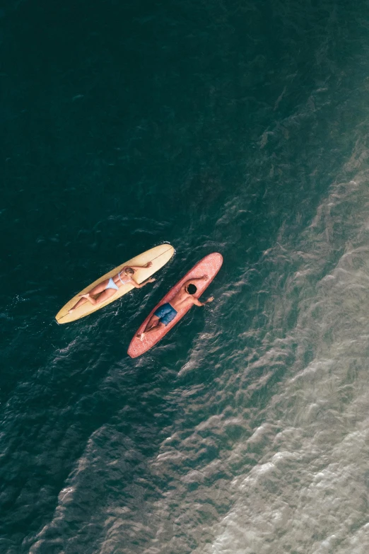 a couple of people riding surfboards on top of a body of water, pexels contest winner, small canoes, looking down from above, maroon, slide show