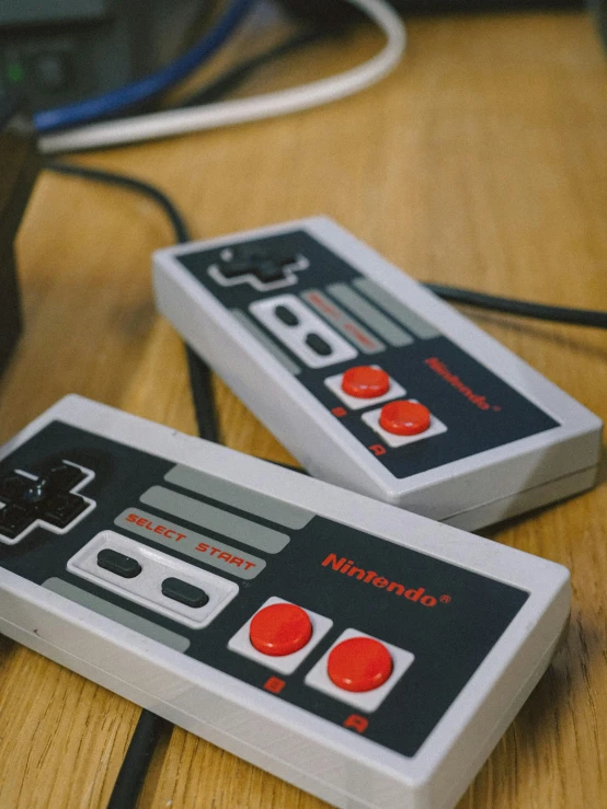 a couple of nintendo controllers sitting on top of a wooden table, inspired by Miyamoto, unsplash, pixel art, 2 5 6 x 2 5 6 pixels, historical photo, live-action archival footage, pair of keycards on table