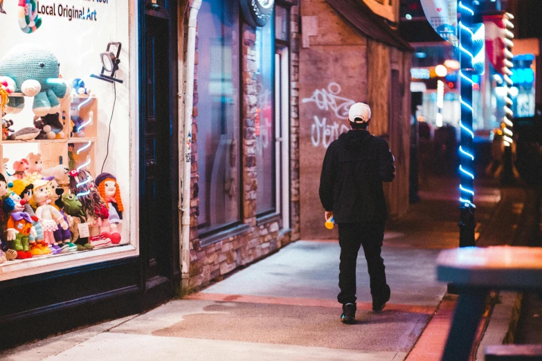 a person walking down a sidewalk in front of a store, pexels contest winner, long night cap, montreal, adult video store, people outside eating meals