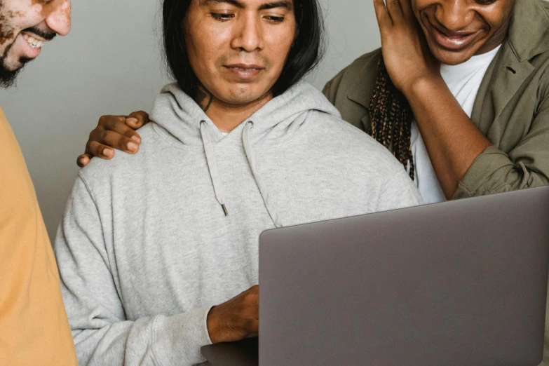 three men and a woman looking at a laptop, by Matija Jama, trending on pexels, indigenous, comforting, background image, woman holding another woman