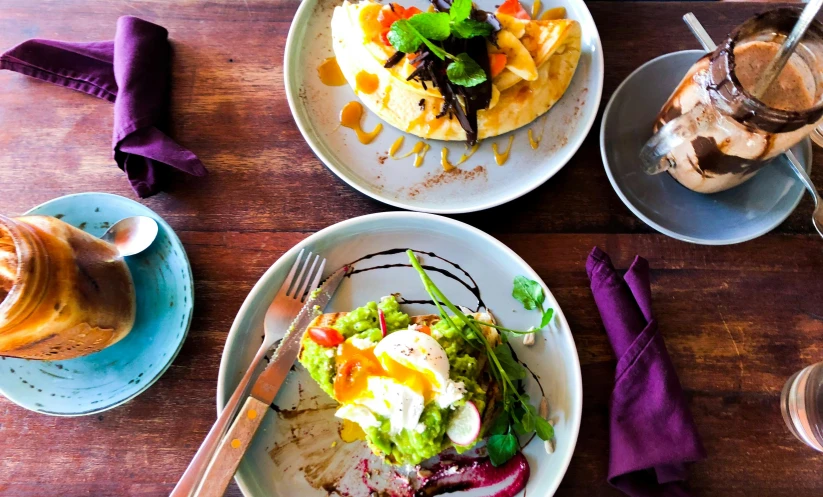 a wooden table topped with plates of food, by Lee Loughridge, unsplash, renaissance, chilaquiles, avacado chairs, caulfield, thumbnail