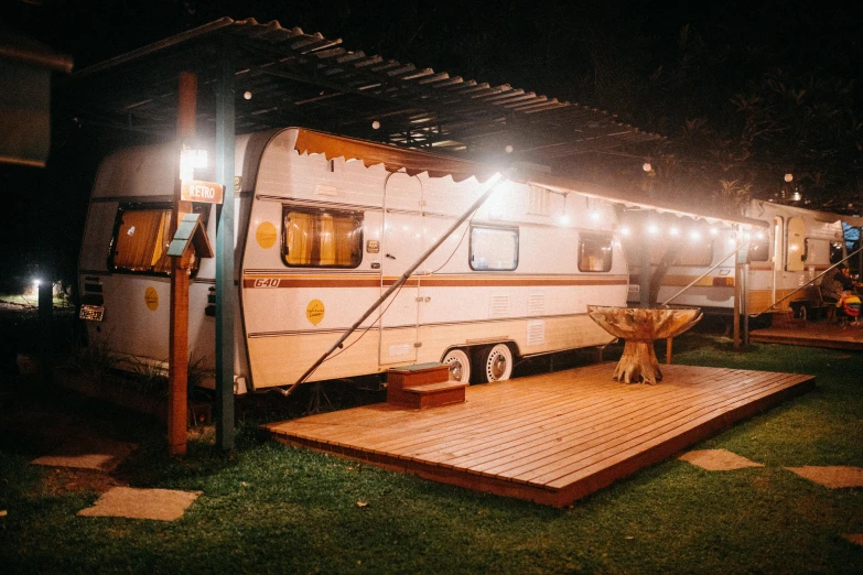 an old camper is lit up at night, unsplash contest winner, renaissance, covered outdoor stage, bulli, deck, lots of space