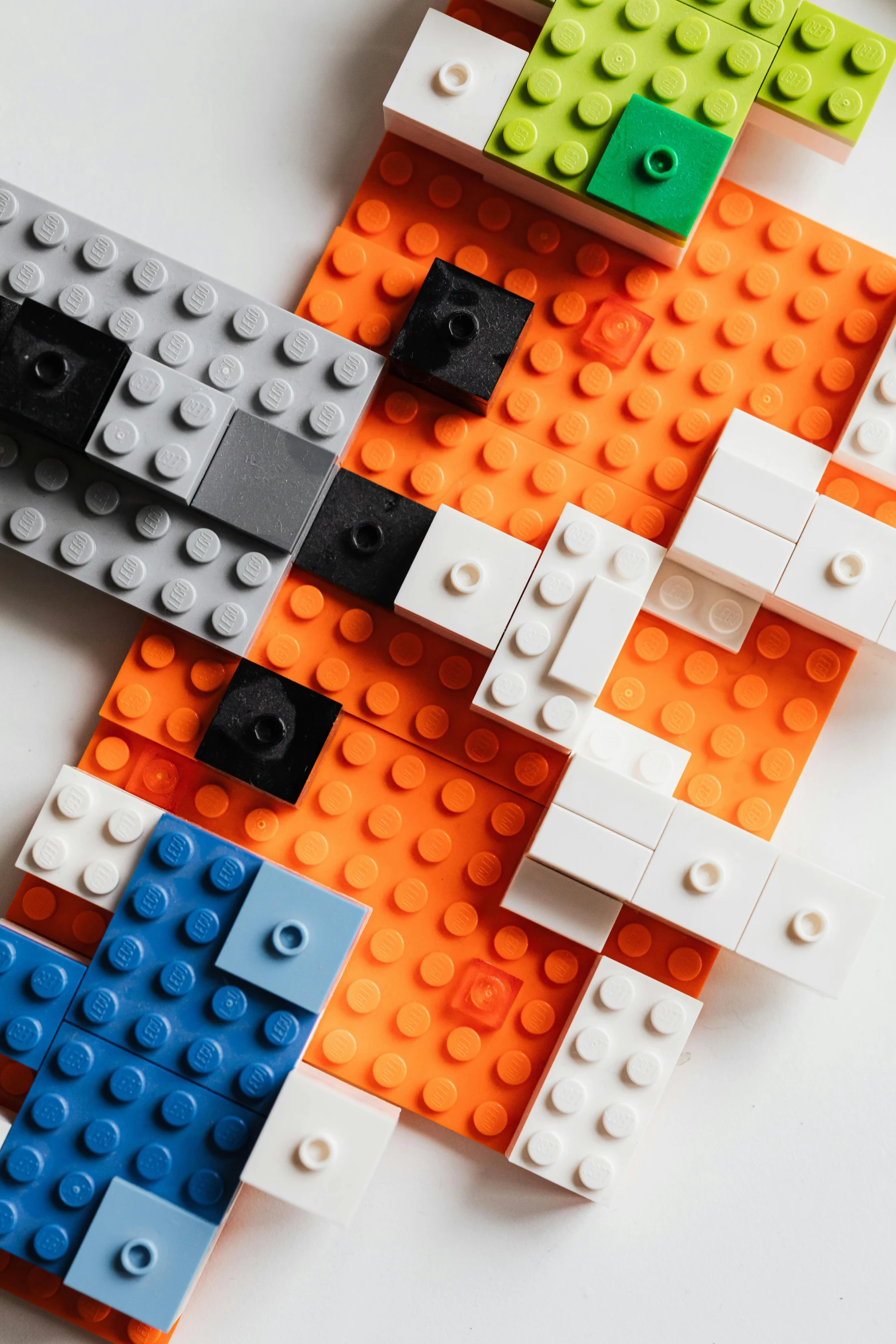 a group of legos sitting on top of a table, an abstract sculpture, inspired by Bauhaus, unsplash, orange and blue, detail texture, square shapes, adafruit