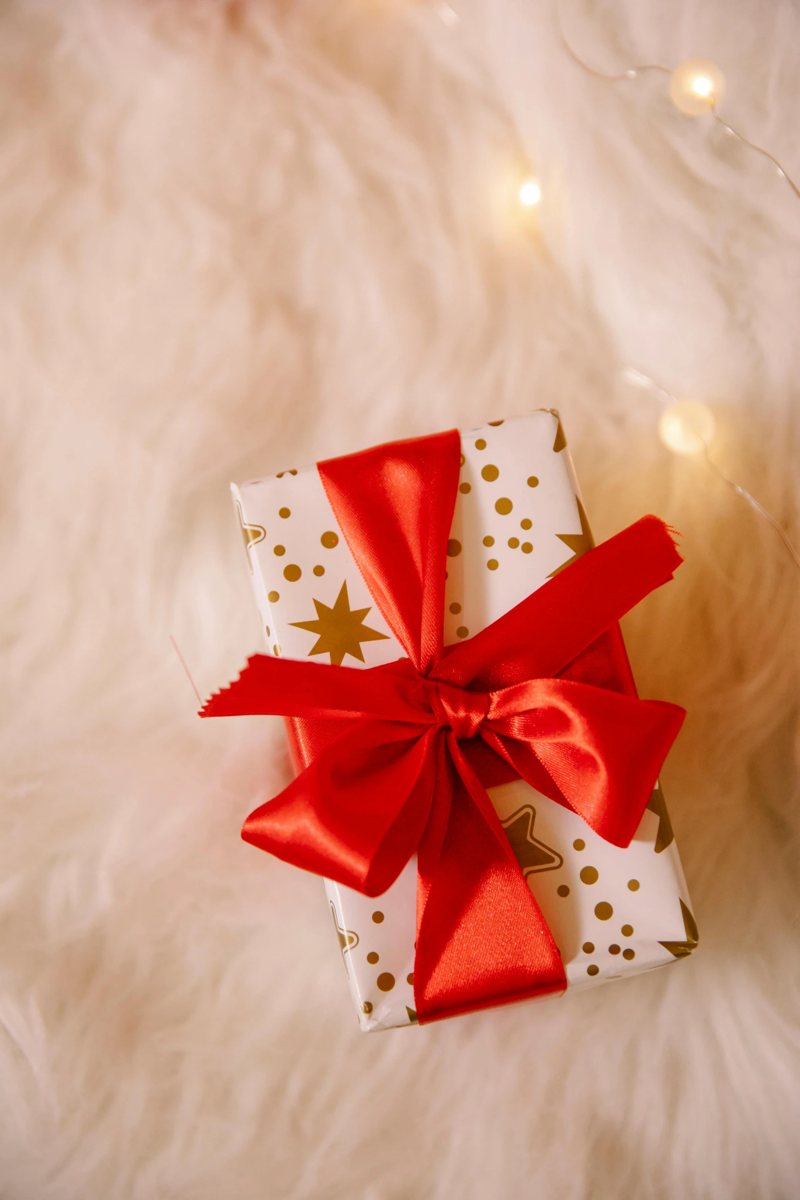 a white gift box with a red bow on top of it, by Julia Pishtar, ethereal soft and fuzzy glow, thumbnail, profile image, holiday vibe