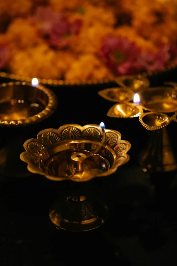 a group of candles sitting on top of a table, hindu ornaments, liquid gold, medium level shot, fan favorite