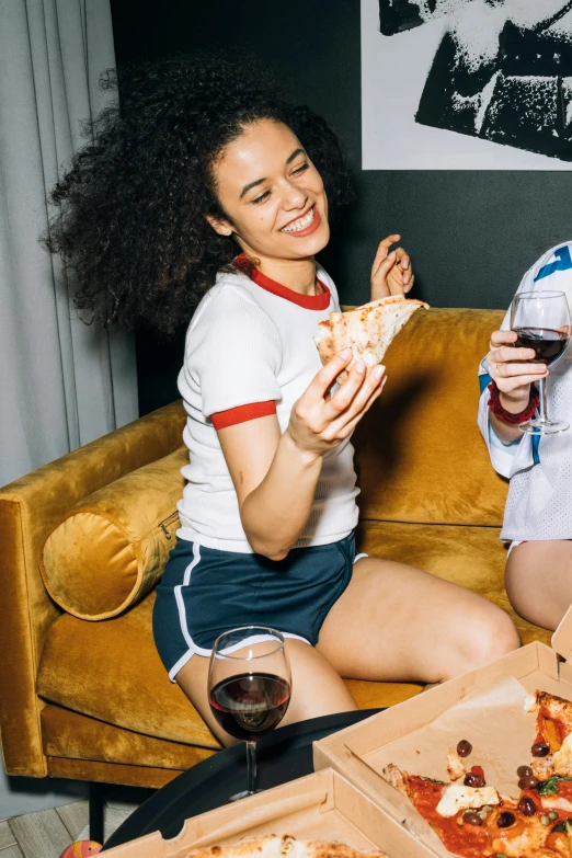 two women sitting on a couch eating pizza, pexels contest winner, renaissance, tan skin a tee shirt and shorts, red wine, woman in streetwear, superbowl
