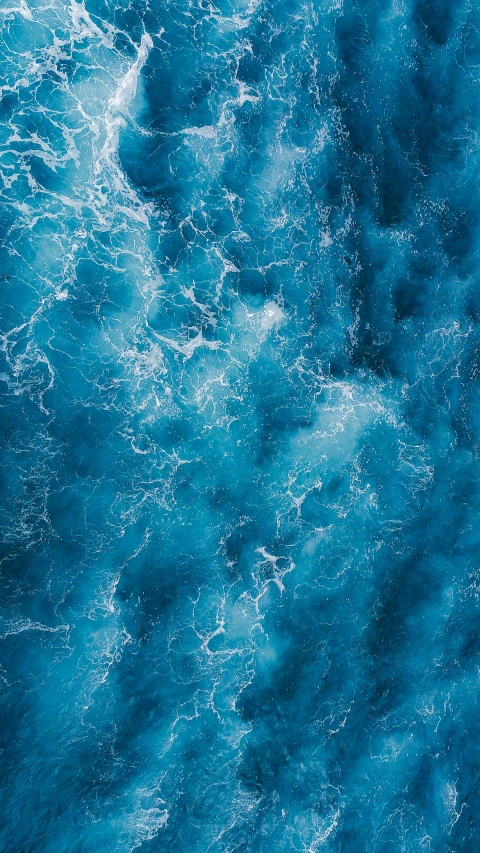 an aerial view of a body of water, an album cover, by Jacob Toorenvliet, pexels, turbulent sea, vibrant blue, instagram post, concerned