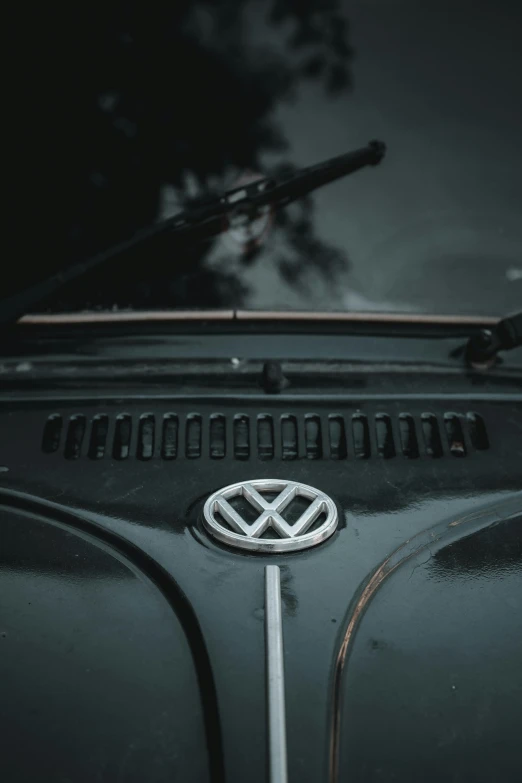 a close up of a vw emblem on the hood of a car, unsplash contest winner, low quality photo, nostalgic 8k, open top, grey