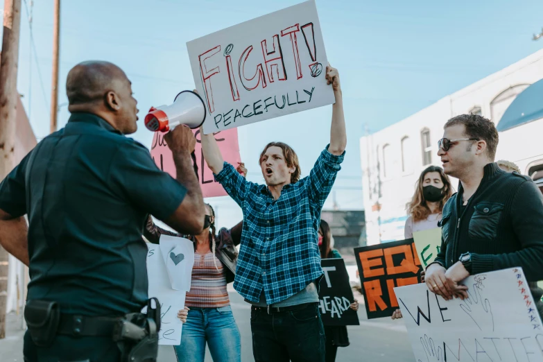 a group of people standing on a street holding signs, by Drew Tucker, pexels, fight scene, a photo of a man, contain, background image