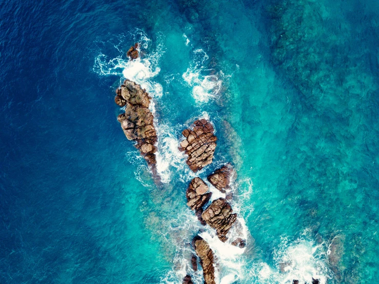 an aerial view of the ocean and rocks, pexels contest winner, sirens, blue, manly, icon