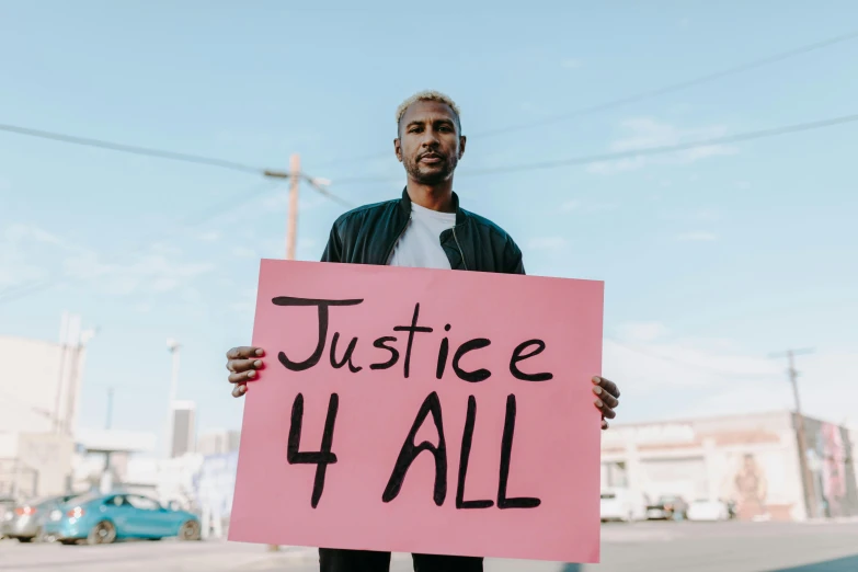 a man holding a sign that says justice 4 all, trending on pexels, ashteroth, instagram post, ad image, benefit of all