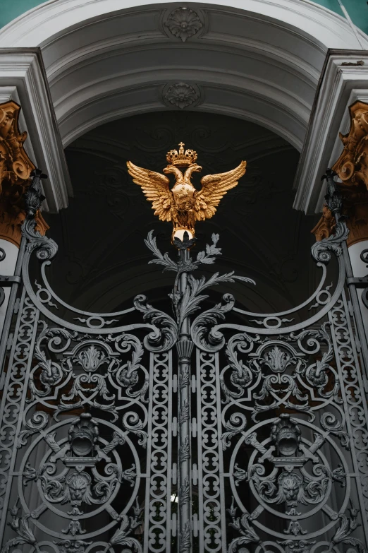 a close up of a metal gate with a bird on it, by Serhii Vasylkivsky, baroque, light above palace, an eagle, black and gold rich color, nicholas ii of russia