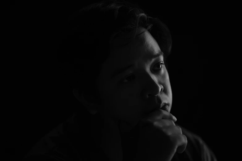 a black and white photo of a woman in the dark, pexels contest winner, detailed face of a asian boy, pondering, animation still, high quality photo
