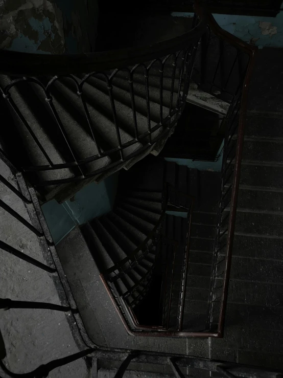 a close up of a spiral staircase in a building, an album cover, inspired by Katia Chausheva, ((unreal engine)), dark aesthetic, low quality photo, ignant