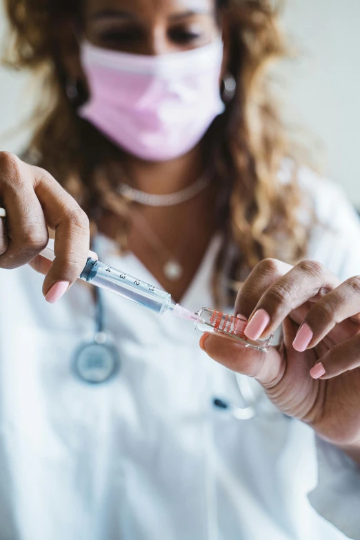 a woman in a white lab coat is holding a syssor, a picture, shutterstock, renaissance, holding syringe, instagram photo, surgical gown and scrubs on, diverse